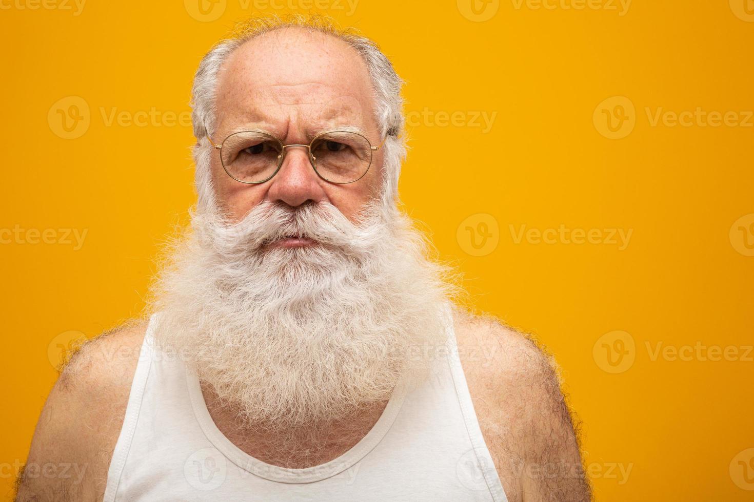 Old man with a long beard on a yellow background. Senior with full white beard. Old man with a long beard with sadness. photo