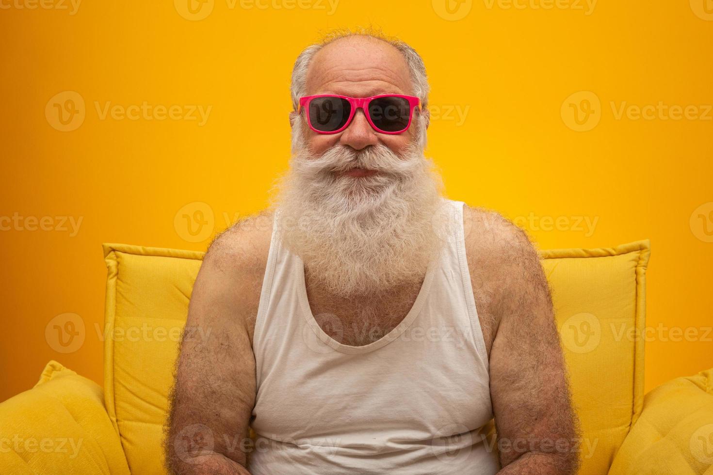 Happy old man with a red nose. All fools day. Elderly with red nose and pink glasses. photo