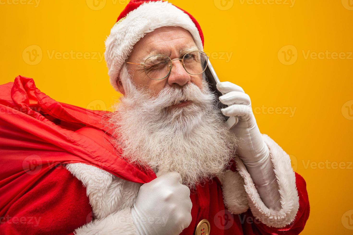 Holly jolly x mas Santa in headwear, costume, black belt, white gloves brings gifts for kids, prepared to celebrate, sale promotion, winter december, chatting on telephone. Santa talking on the phone photo