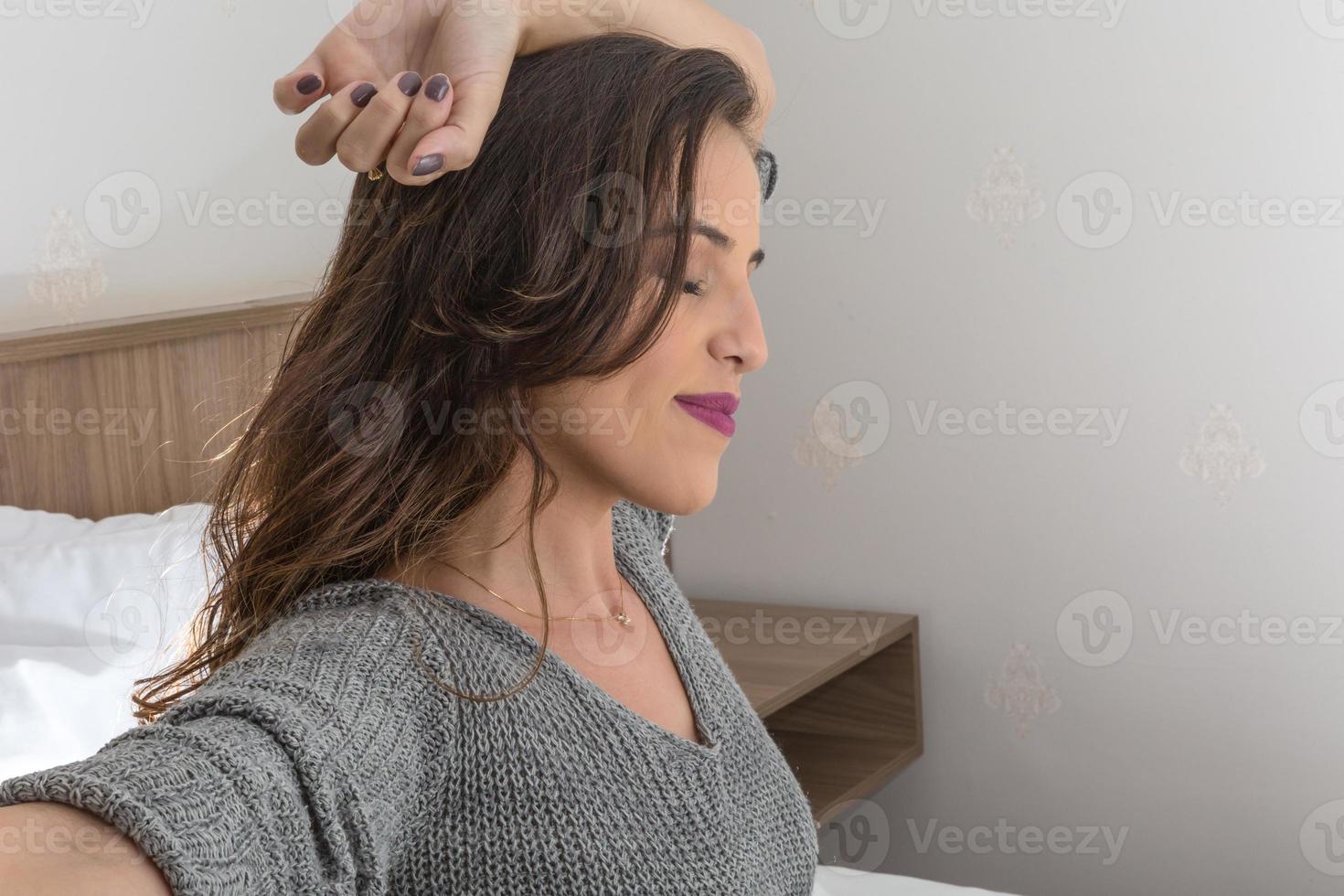 mujer estirándose en la cama después de despertarse foto