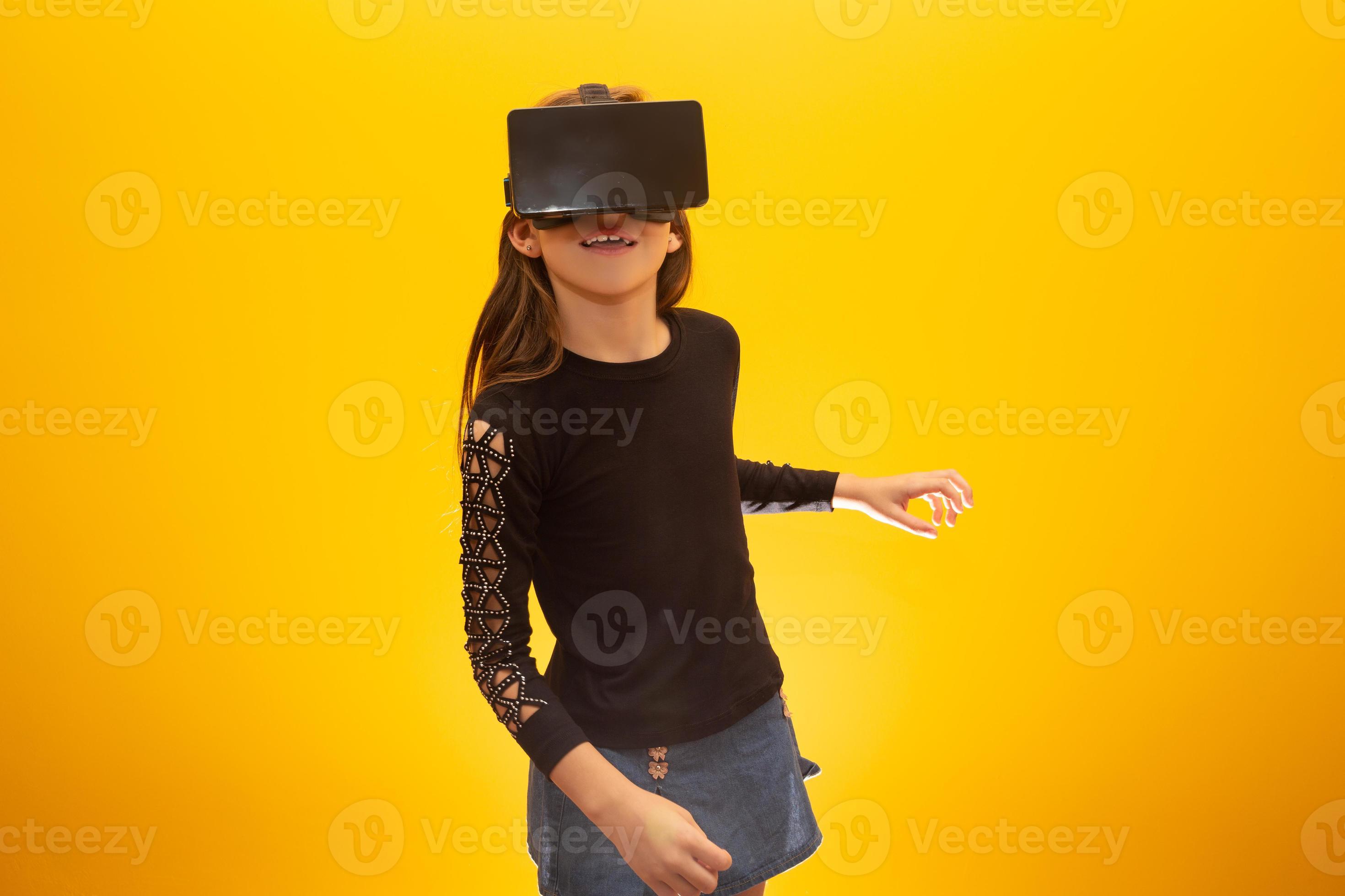 Beliggenhed Vibrere Akademi Happy little girl wearing virtual reality goggles watching movies or  playing video games. Cheerful smiling teenager looking in VR glasses. Funny  child experiencing 3D gadget technology - close up. 7547993 Stock Photo