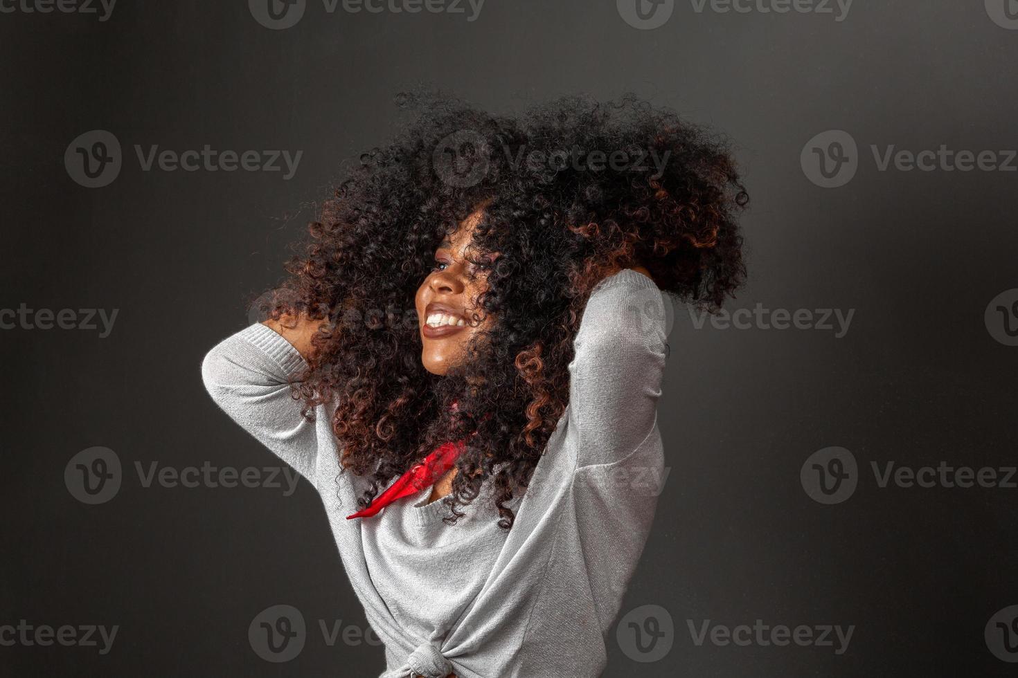 Beauty portrait of african american woman with afro hairstyle and glamour makeup. Brazilian woman. Mixed race. Curly hair. Hair style. Black background. photo
