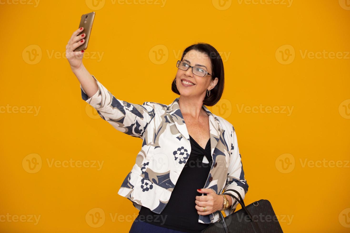 Business woman selfie. Senior beautiful woman with mobile phone photo