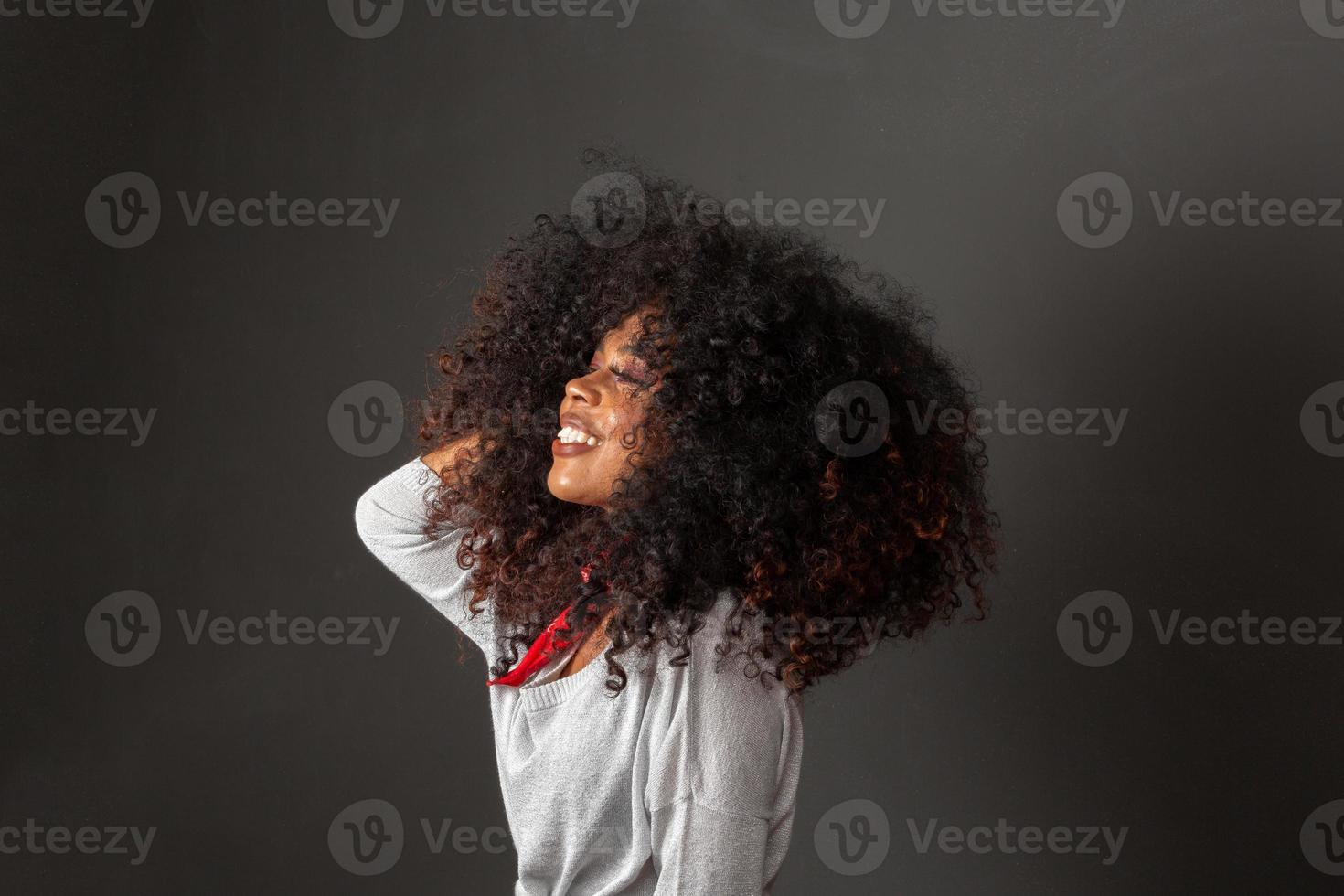 Beauty portrait of african american woman with afro hairstyle and glamour makeup. Brazilian woman. Mixed race. Curly hair. Hair style. Black background. photo