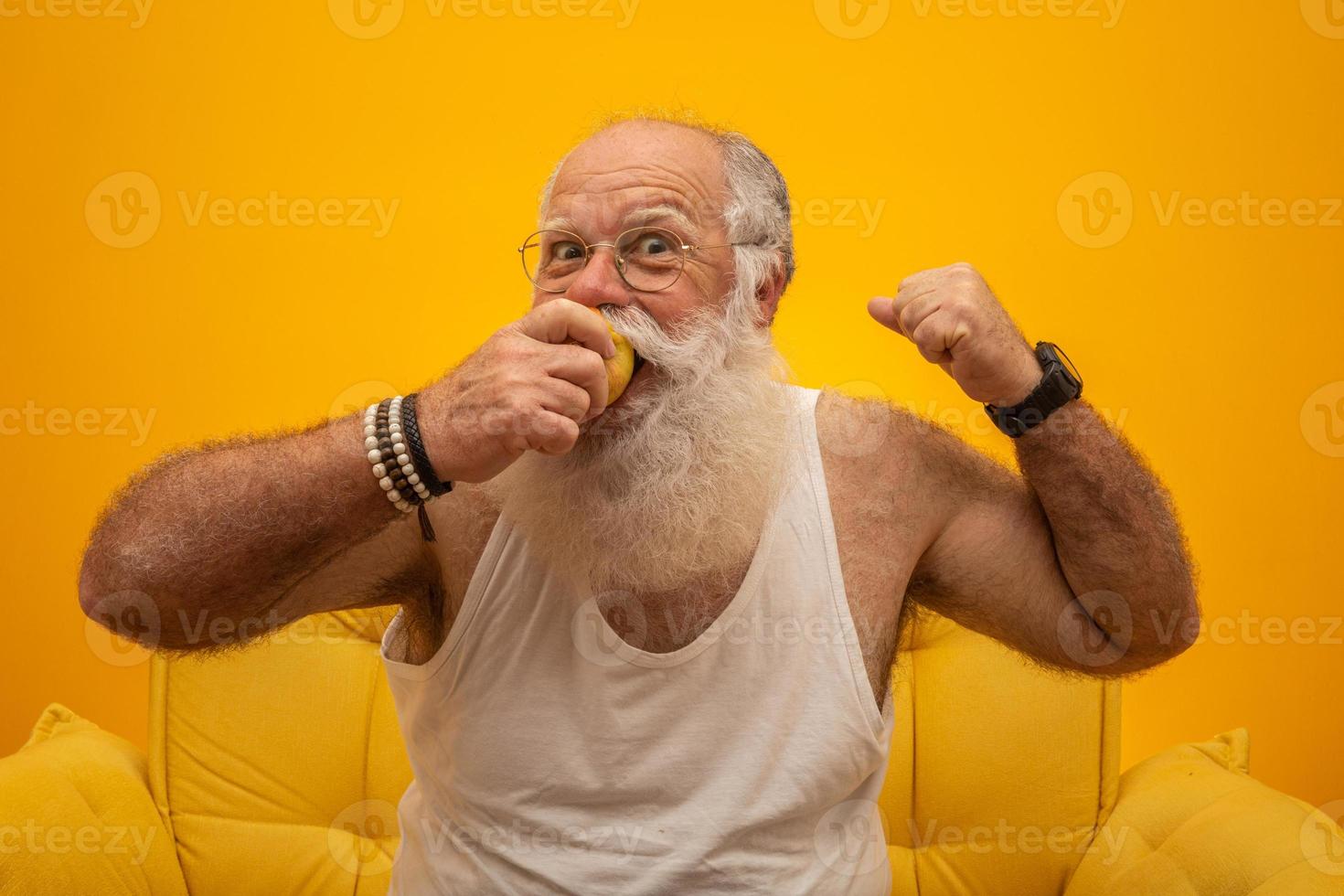 retrato de un hombre barbudo a punto de comer una manzana. senior con una manzana. foto