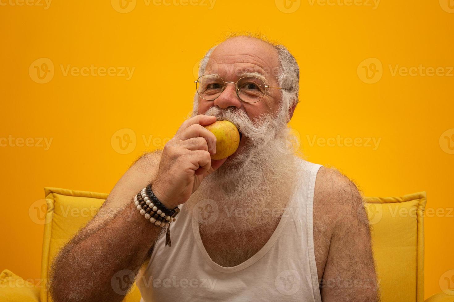 retrato de un hombre barbudo a punto de comer una manzana. senior con una manzana. foto