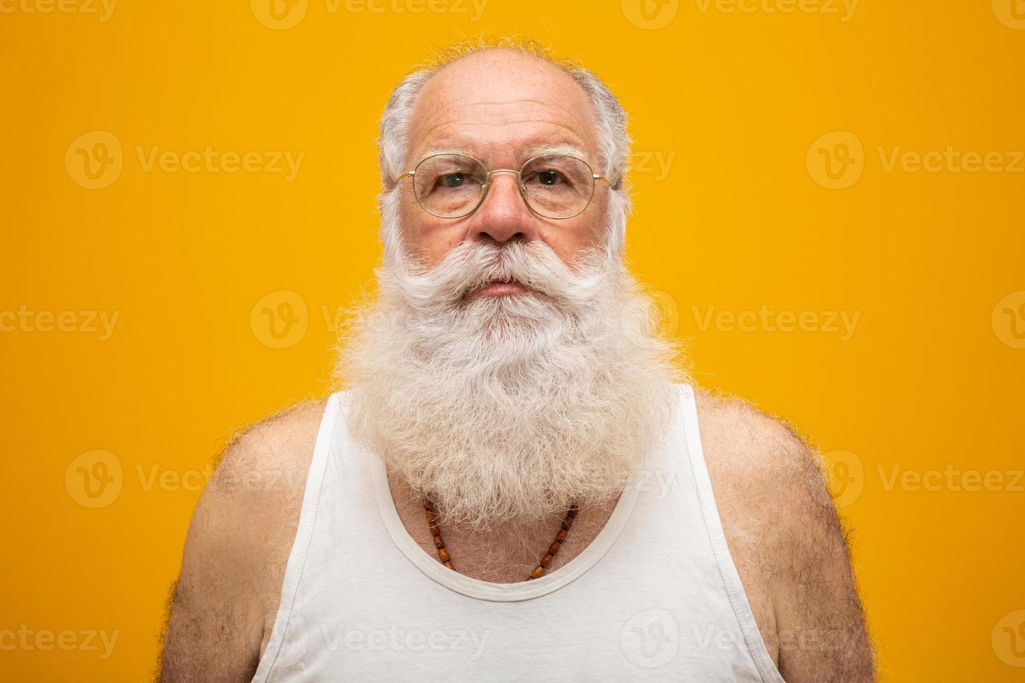 Old man with a long beard on a yellow background. Senior with full white beard. Old man with a long beard with sadness. photo