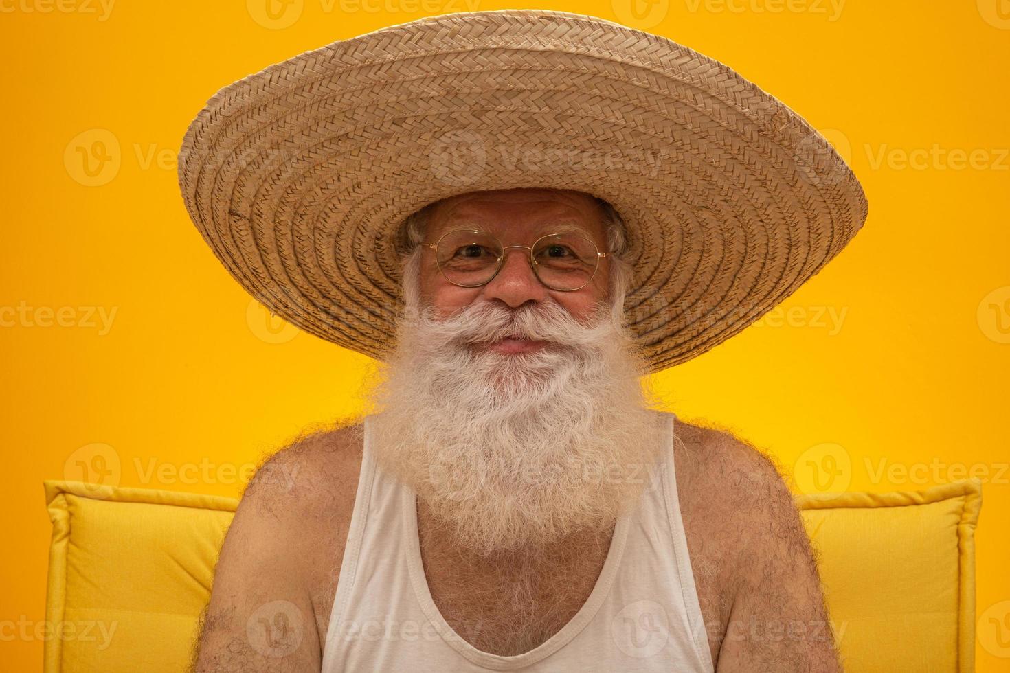 anciano con larga barba blanca con un gran sombrero de paja. foto