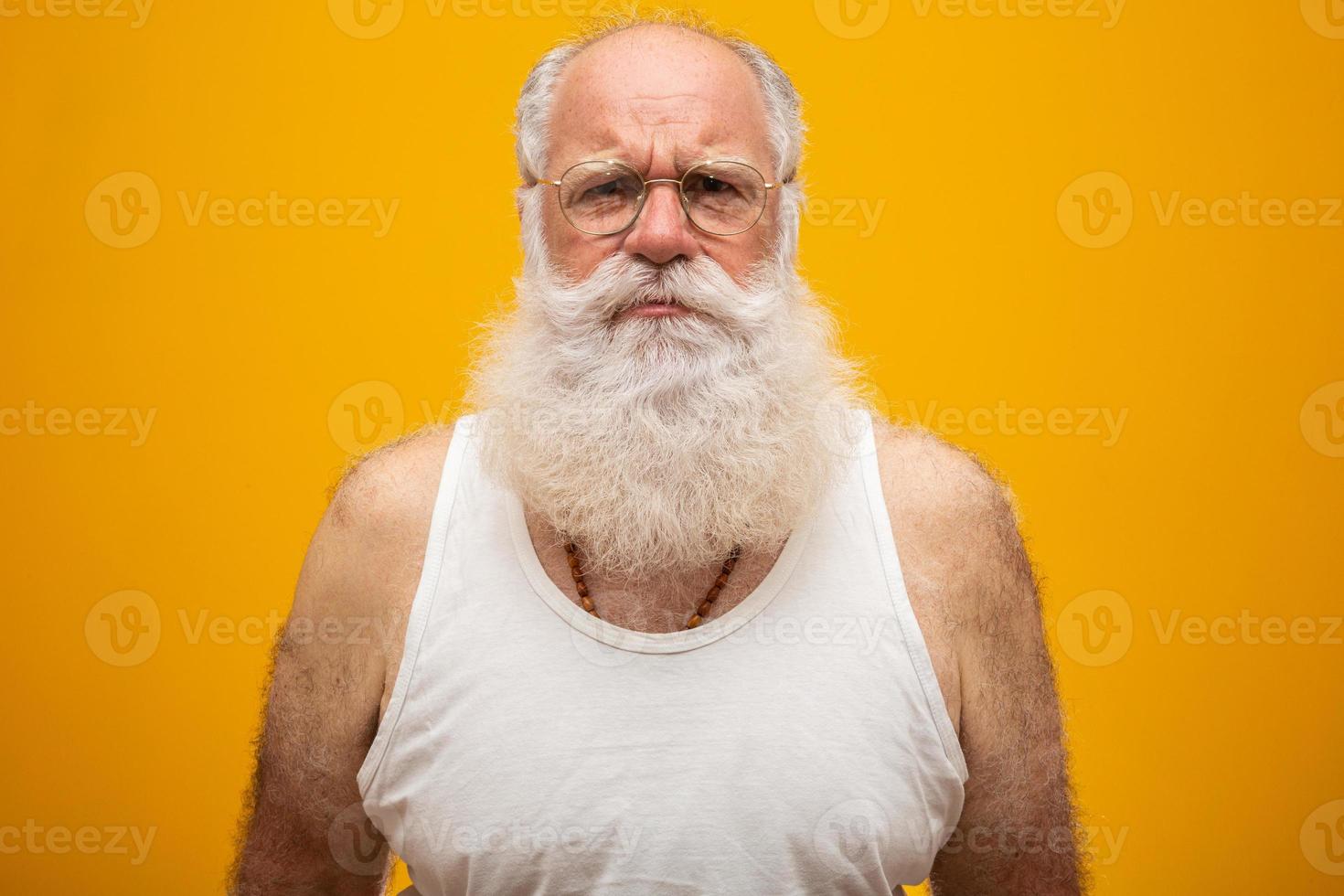 Old man with a long beard on a yellow background. Senior with full white beard. Old man with a long beard with sadness. photo