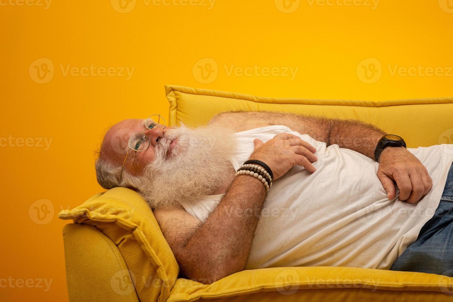 anciano con una barba larga sobre un fondo amarillo. senior con barba blanca completa. anciano con barba larga con tristeza. foto