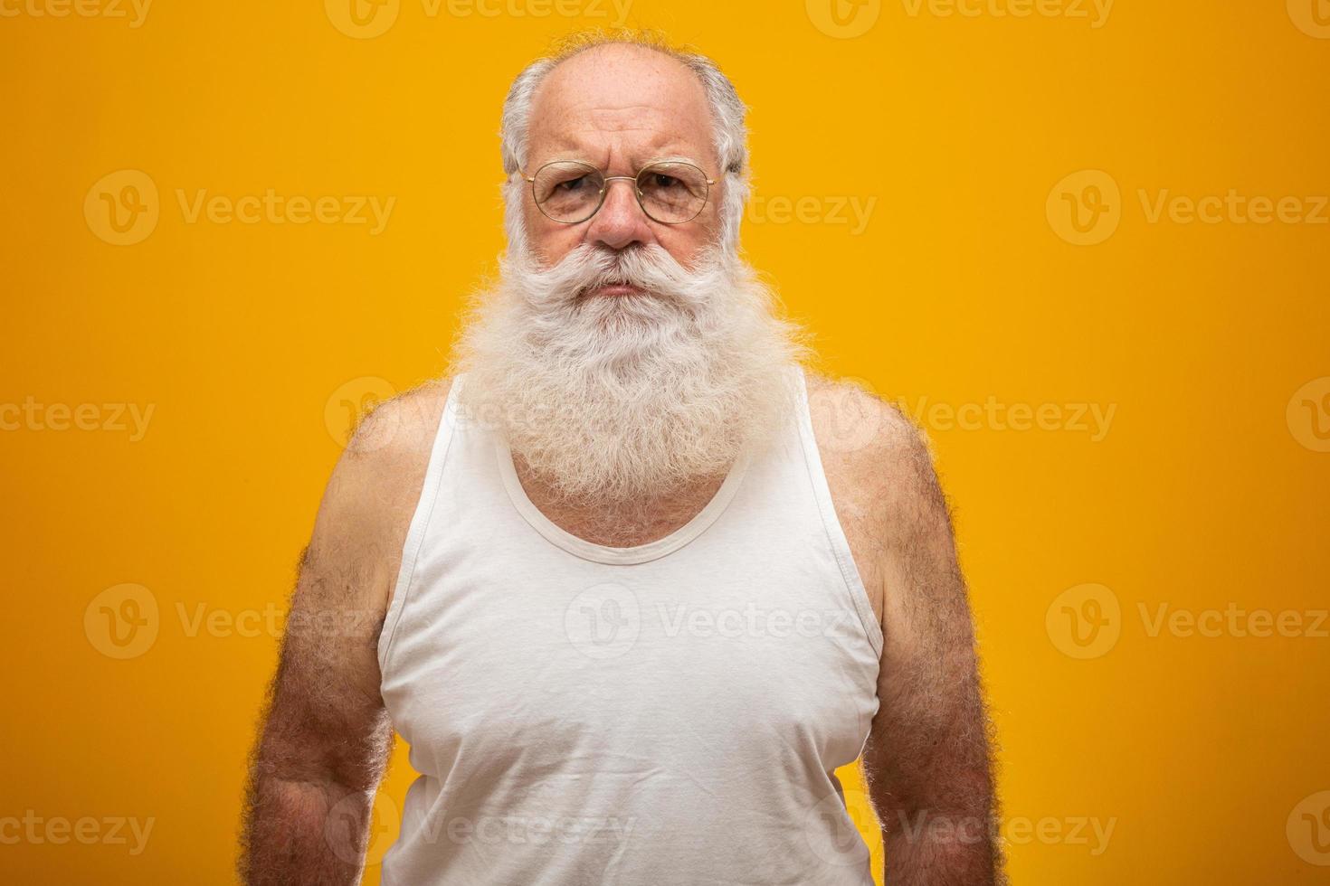 Old man with a long beard on a yellow background. Senior with full white beard. Old man with a long beard with sadness. photo