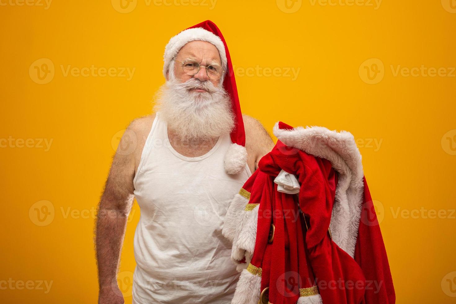 Santa holding his clothes after or before delivering presents. Santa's clothes. Costume. Serious. photo