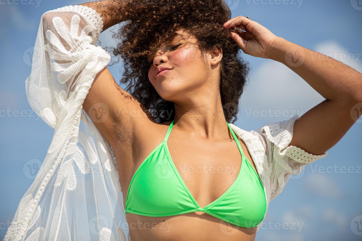 Black afro young cute girl, curly hair, bikini, beach. Afro American summer vacation holiday. photo