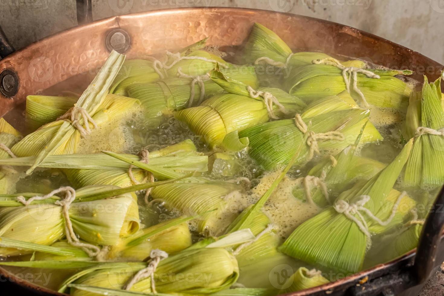 Brazilian sweet corn dessert called Pamonha. Festa Junina Party. Brazilian culture. Cooking in the pan. Wood burning stove. photo