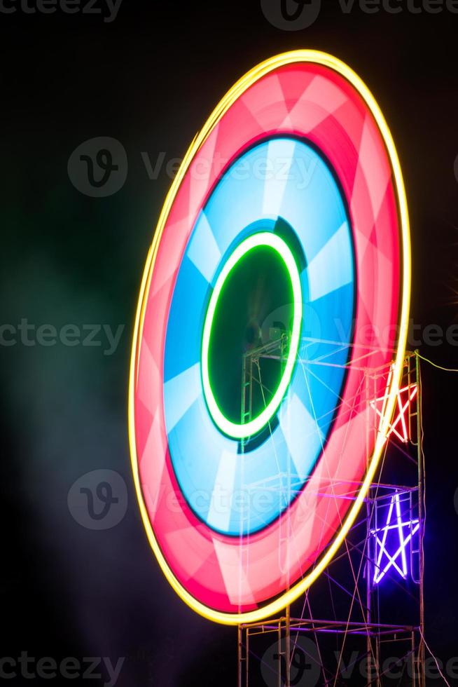 Neon lights rotate colorful circles at night. photo