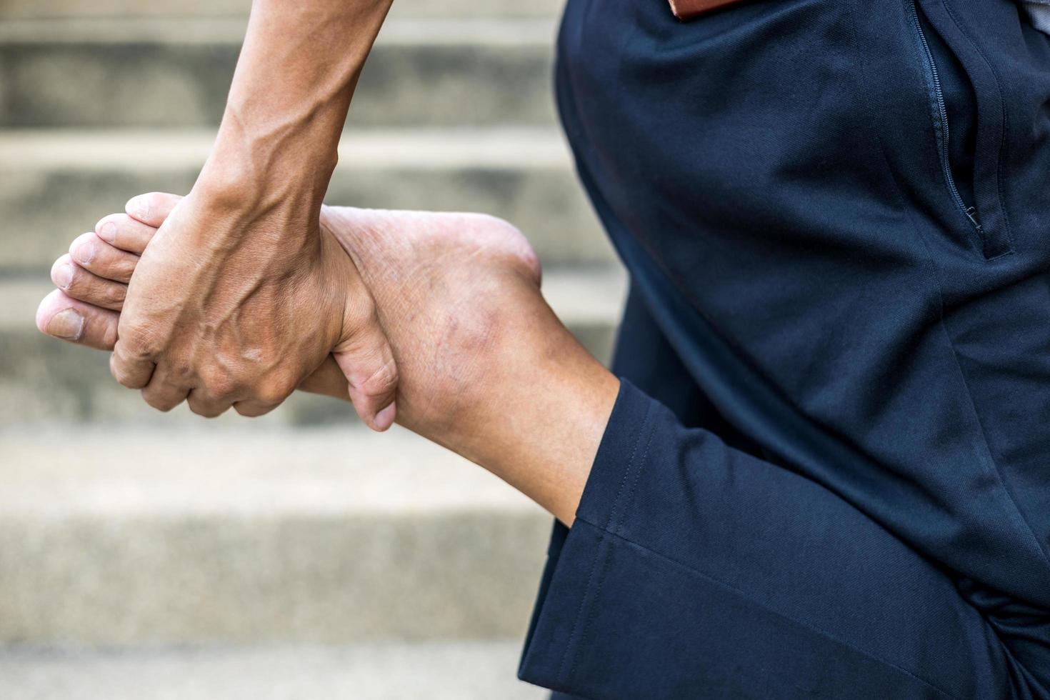 Close-up of the hand of a Thai man standing and bending his feet. photo