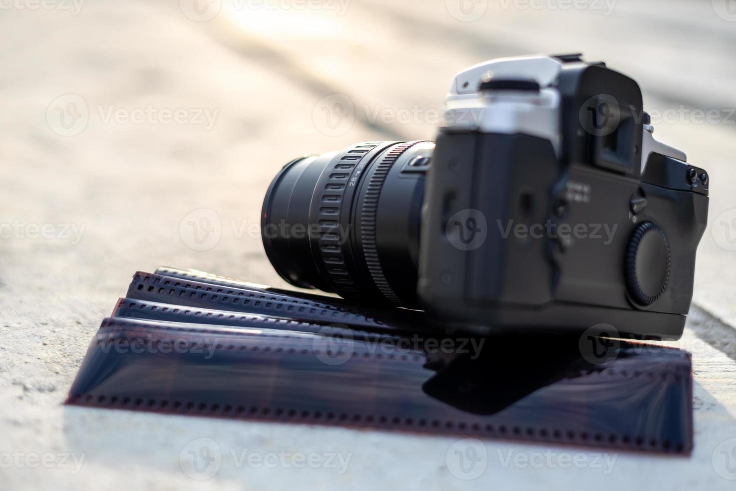 A close-up view of an old black camera and a sheet of film. photo