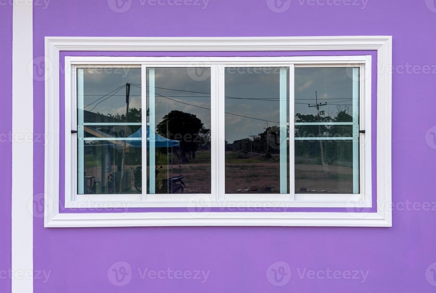 White concrete frame sliding window with purple walls. photo