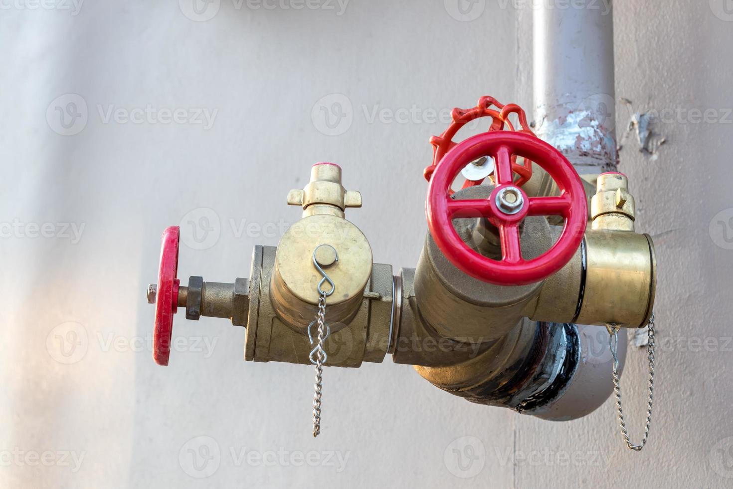 Red valve with pipe near the wall. photo