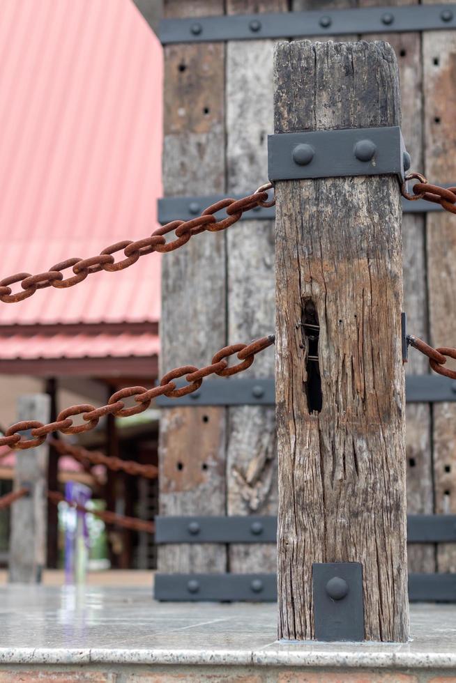 Old wooden pole with rusty chain rust. photo