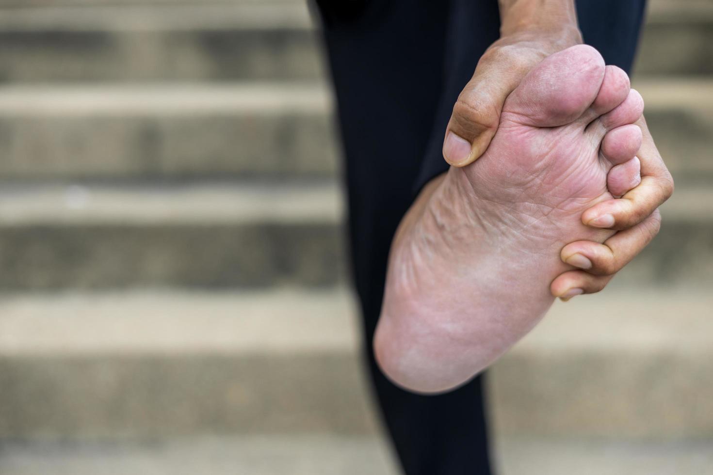 Close-up of the hand of a Thai man standing and bending his feet. photo