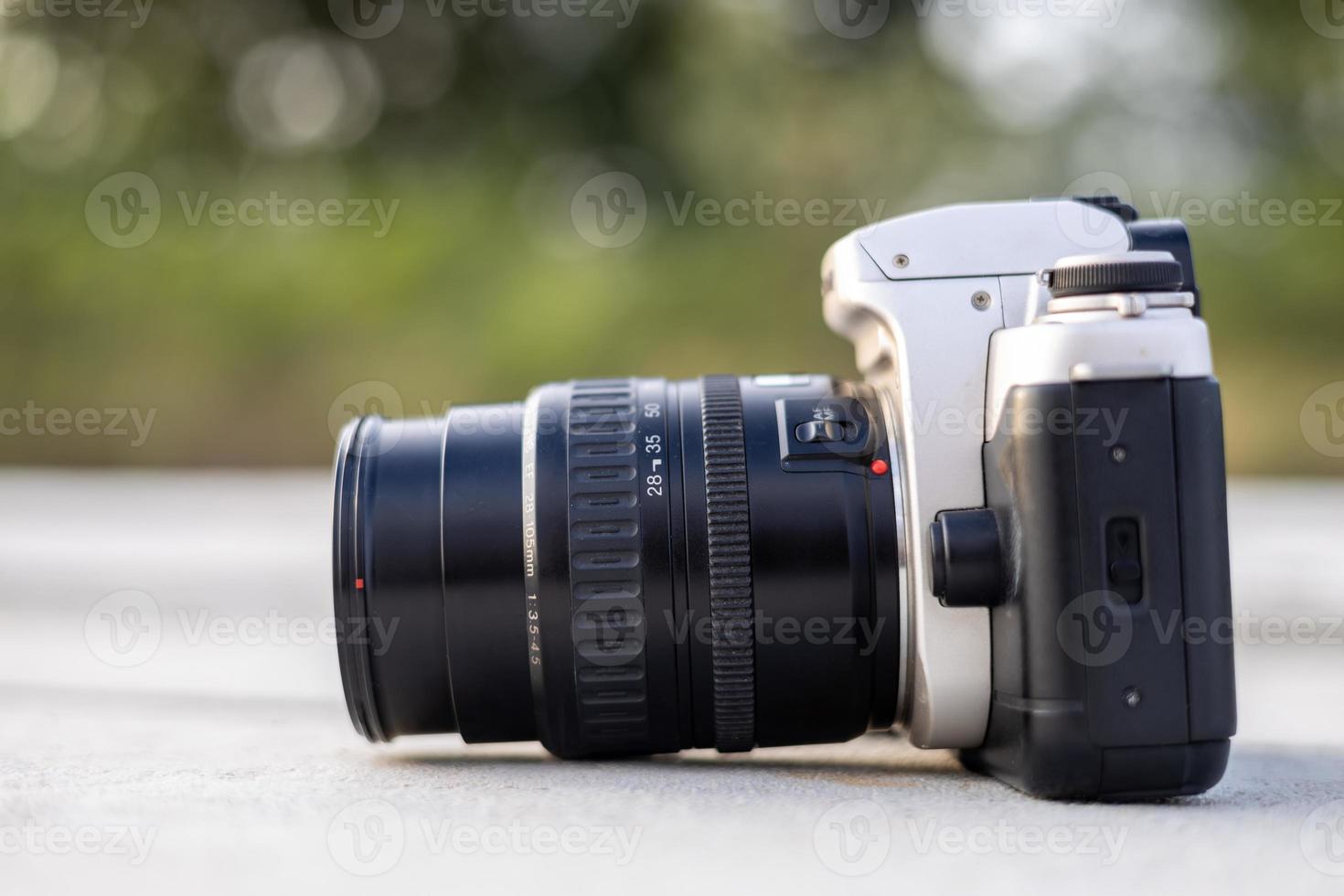 A close-up view of an old black film camera that has been in use for a long time lying. photo