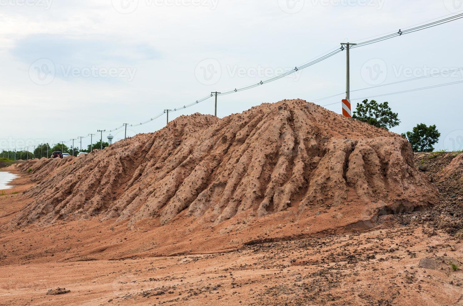 The sand mound on the side of the road has been eroded by water. photo