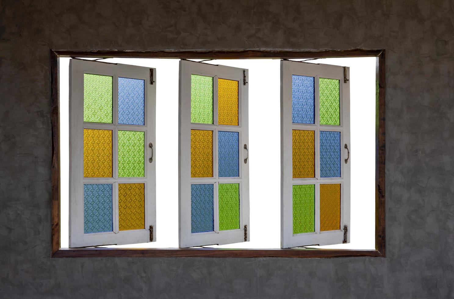 Open the old wooden windows with colorful patterned glass from inside the room. photo