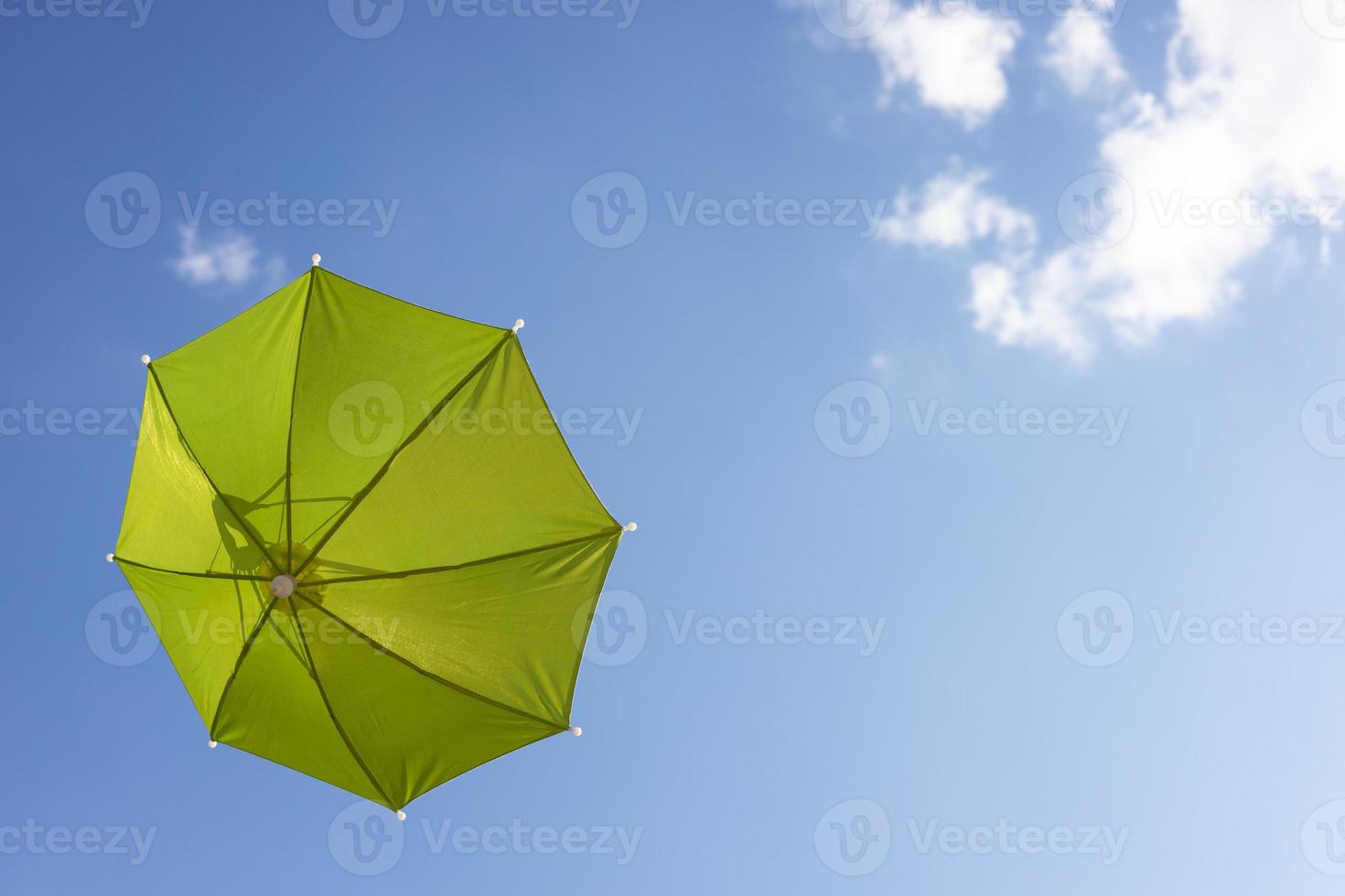 A close-up view from the low, a beautiful, translucent green umbrella floating freely. photo