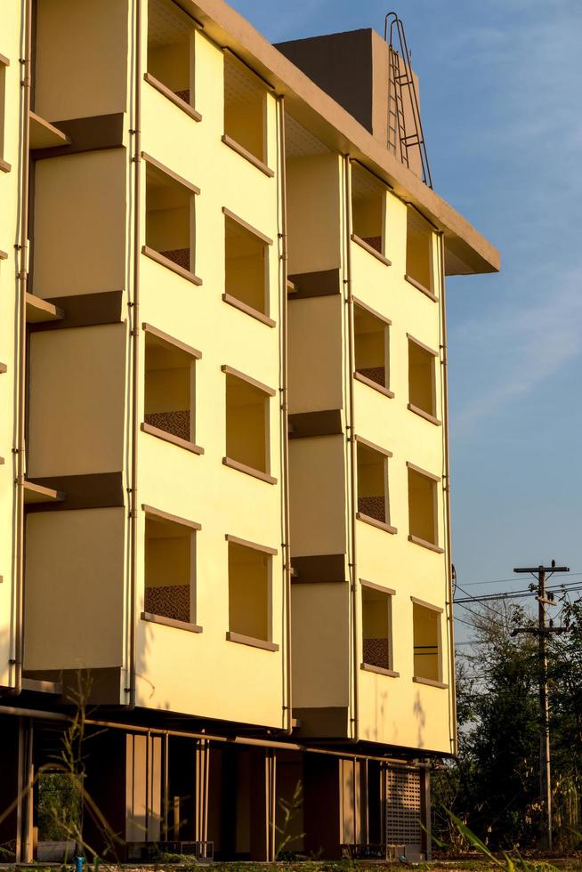 Yellow building with sunlight near the electricity pole. photo