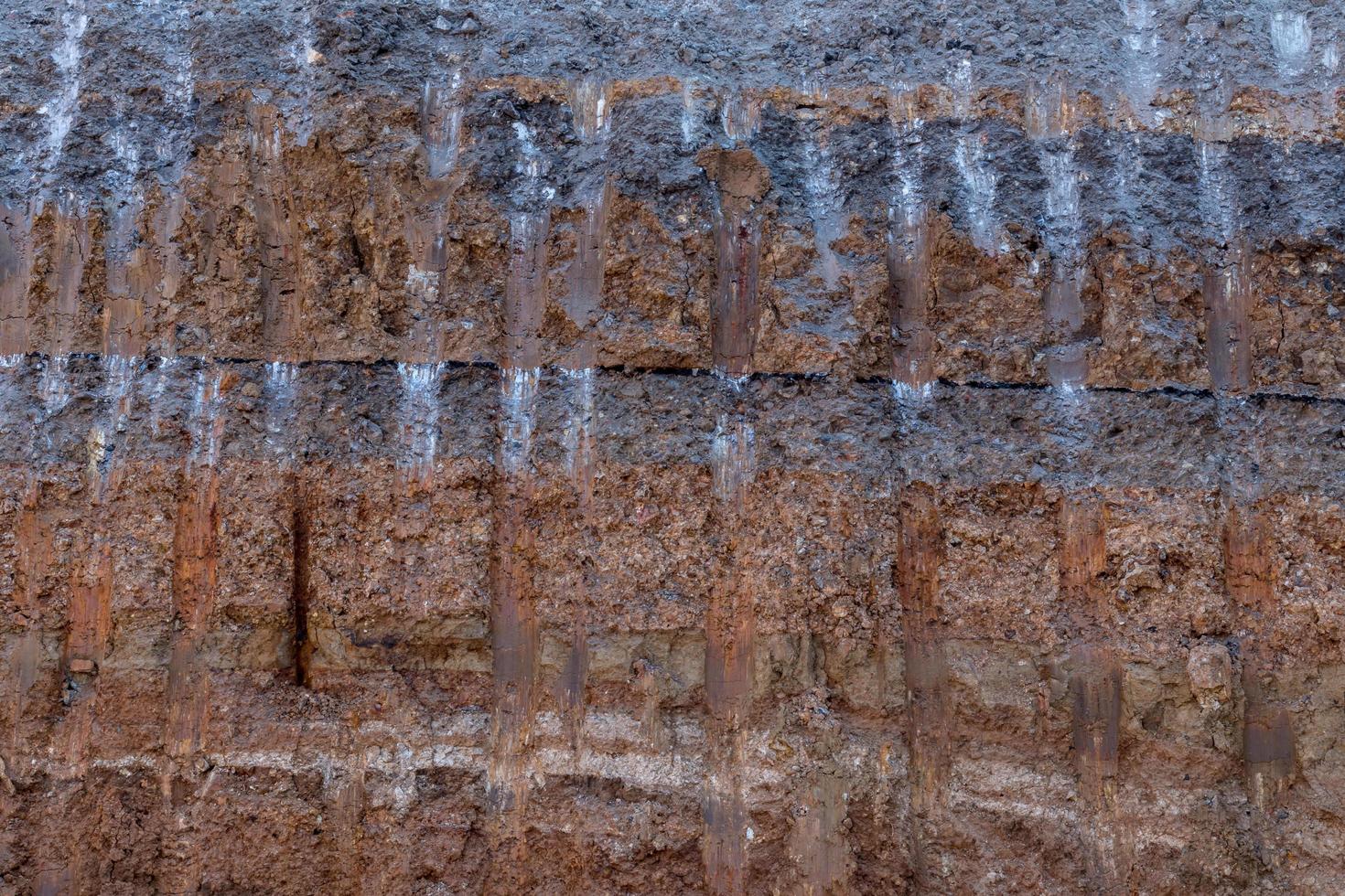 Surface soil layer under the road with digging trails. photo