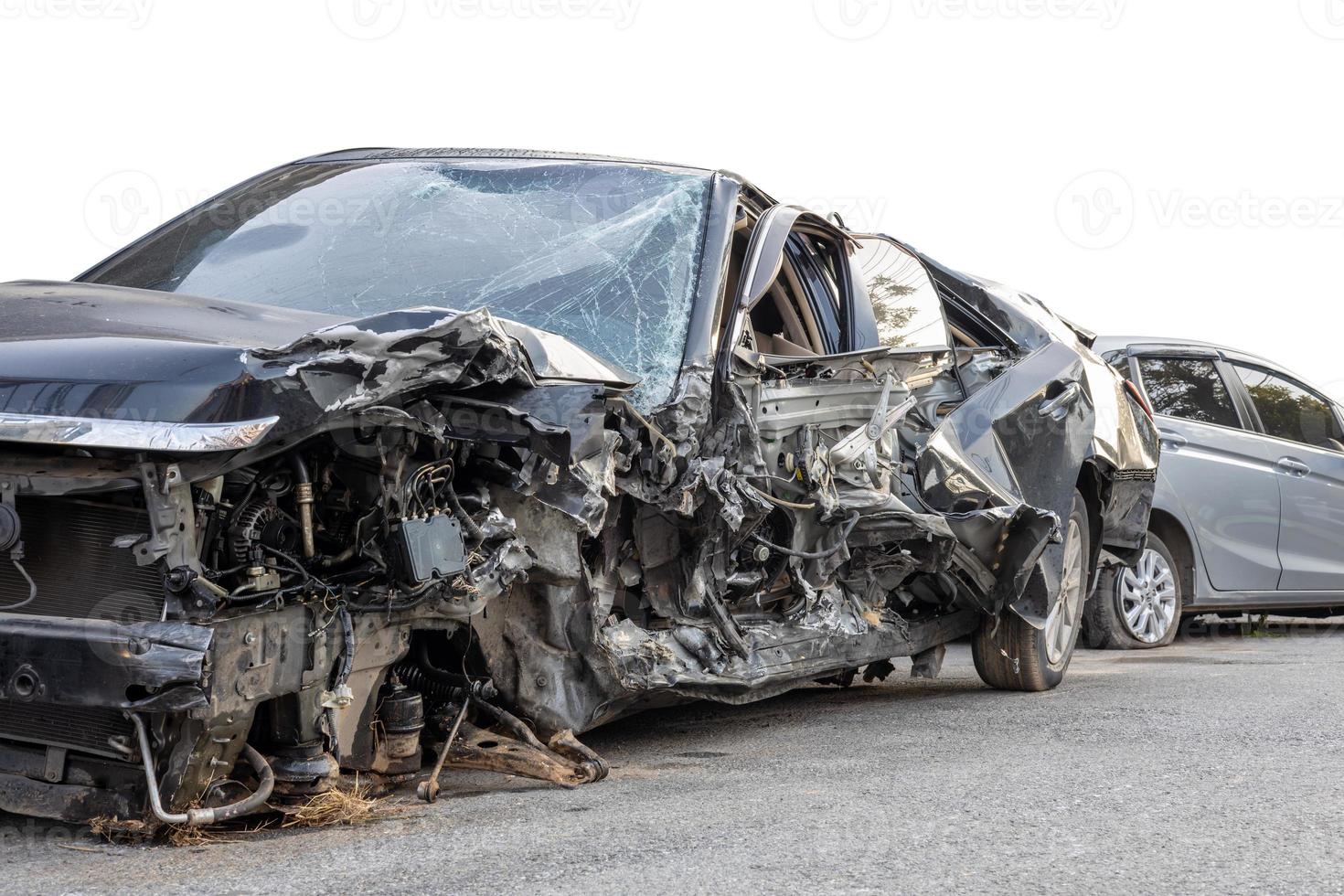 Low side view of a sedan that was smashed in a fatal collision. photo