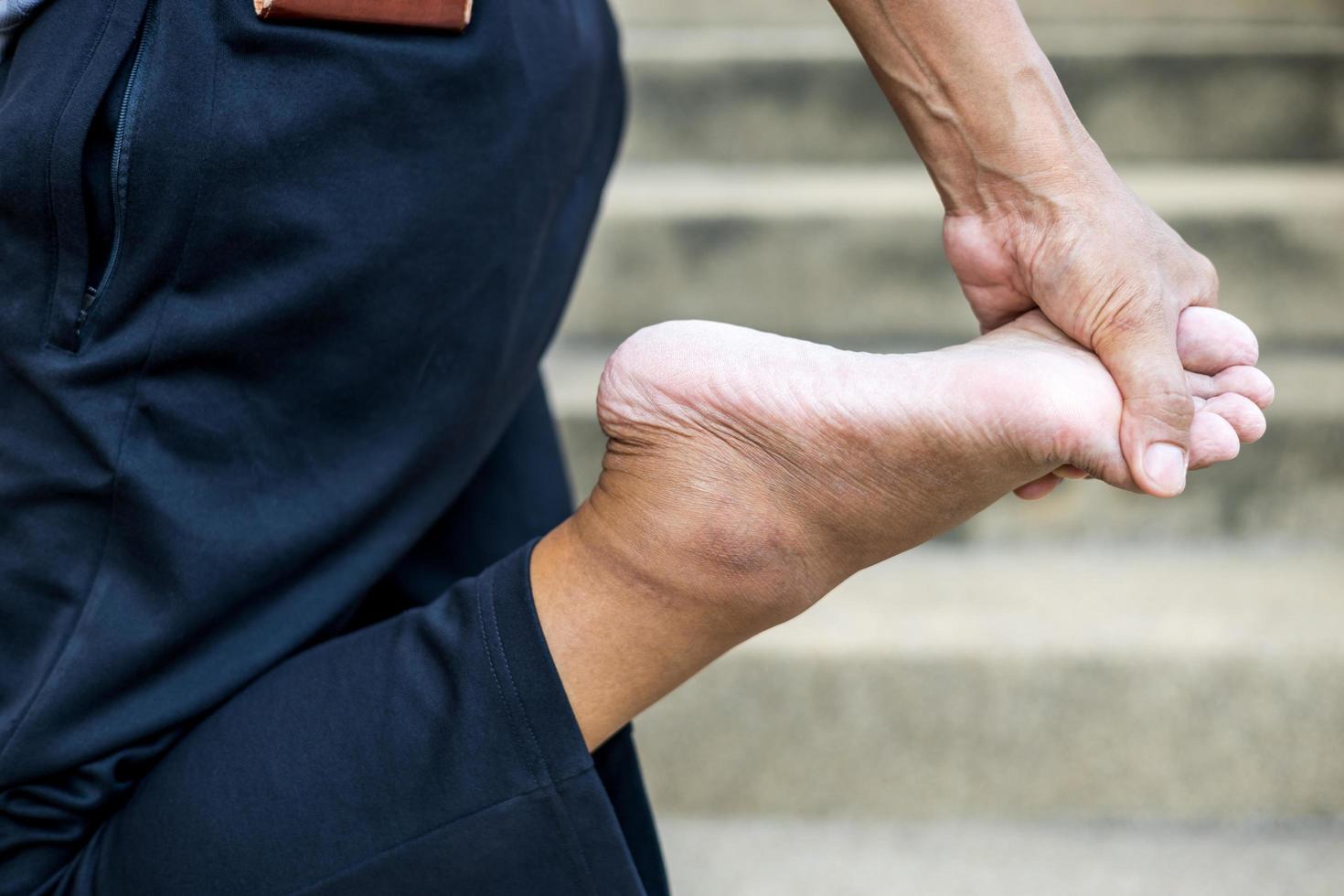 primer plano de la mano de un hombre tailandés de pie y doblando los pies. foto