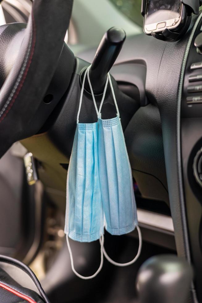 Two pieces of blue face masks hung inside the car. photo