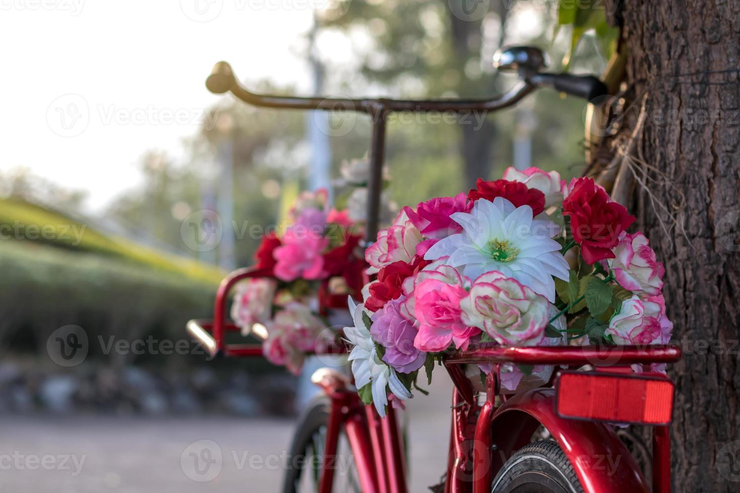 Beautiful artificial flowers on a red antique bike. photo