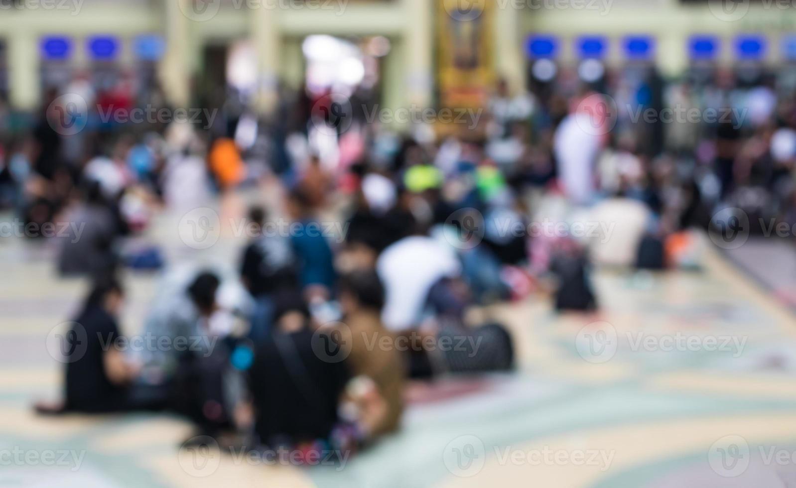 desenfoque de multitud sentada en la estación de espera. foto