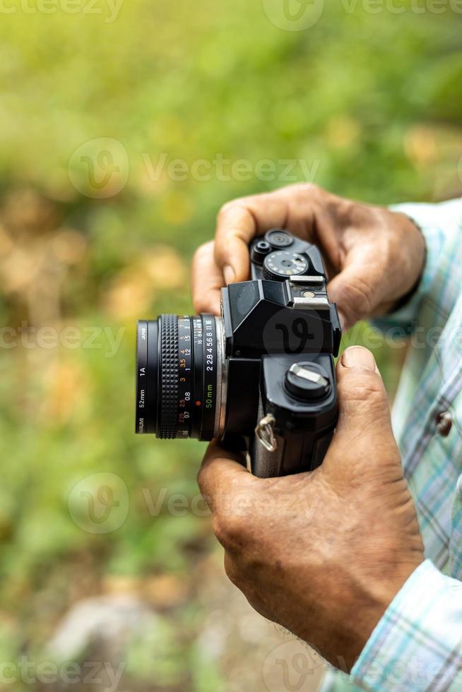 Close-up view from above in elderly hand holding an old film camera. photo