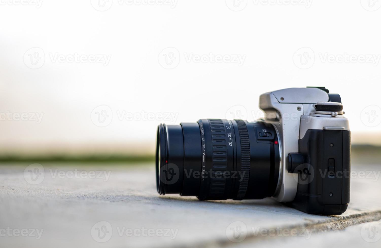 A close-up view of an old black film camera that has been in use for a long time lying. photo