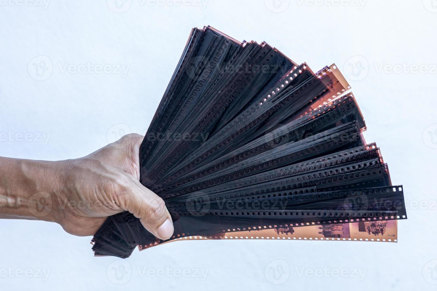 Close-up shot of isolates of male hands holding a lot of stacked 35mm film. photo