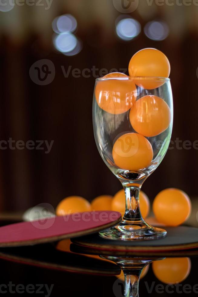 Close-up shot of orange ping pong in clear glass. photo