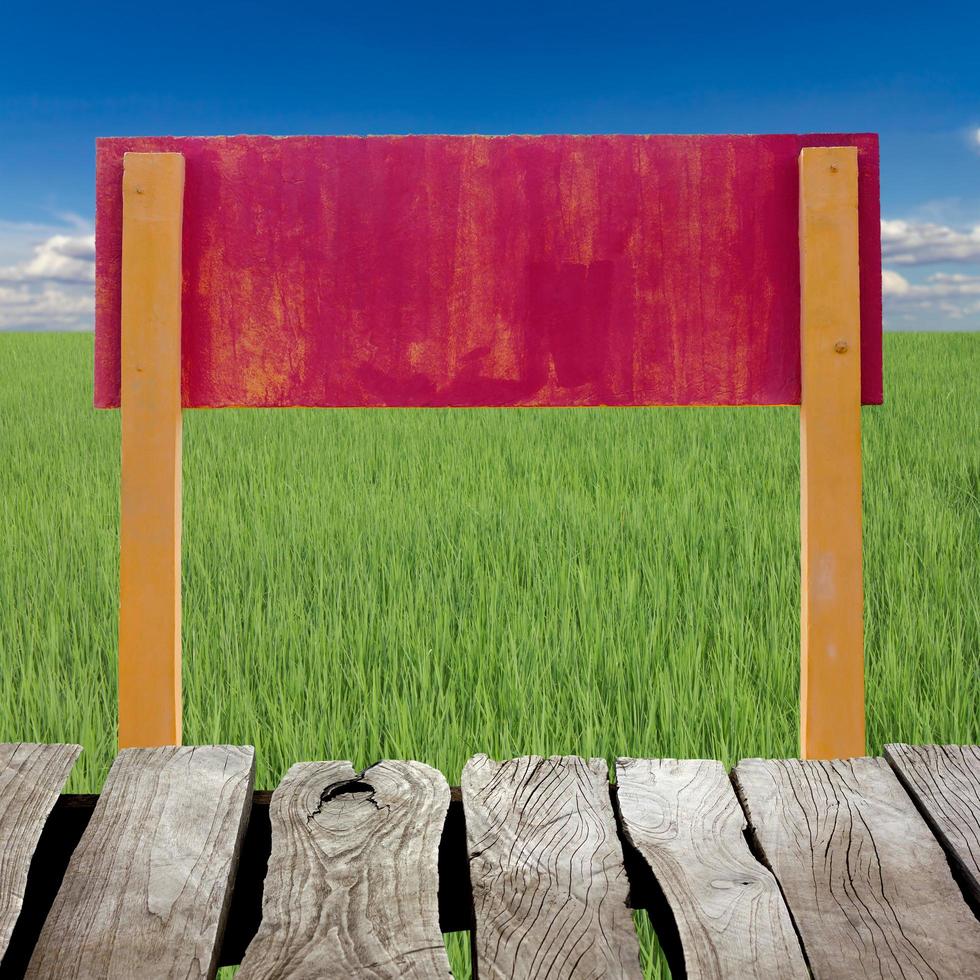 Red concrete sign and wood plate with green grass. photo