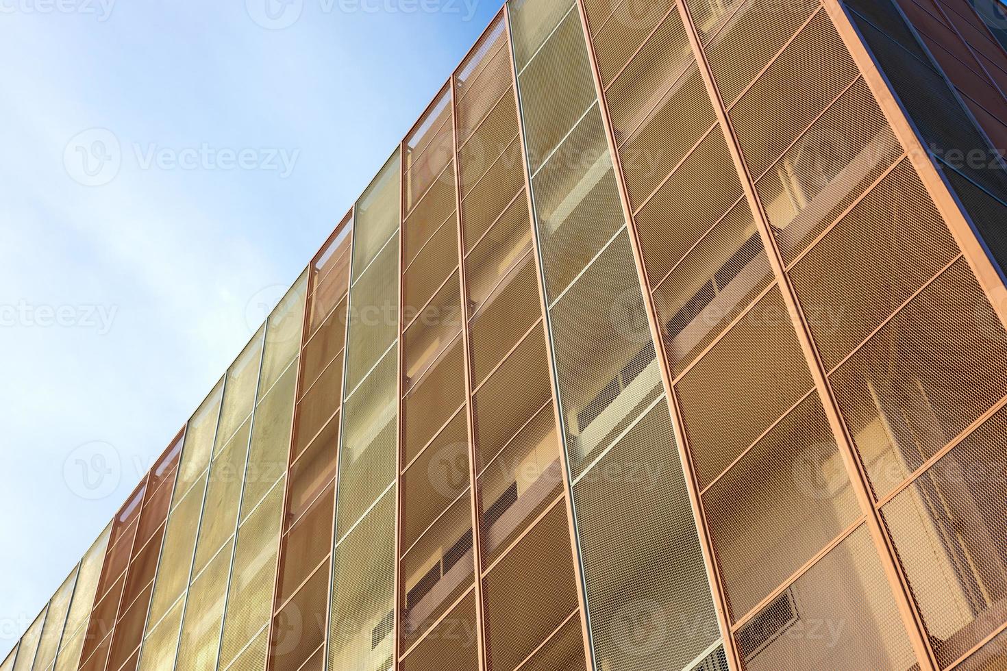 Low angle view, close-up view of the new white tenement buildings, which have been installed with gray and orange steel mesh panels. photo