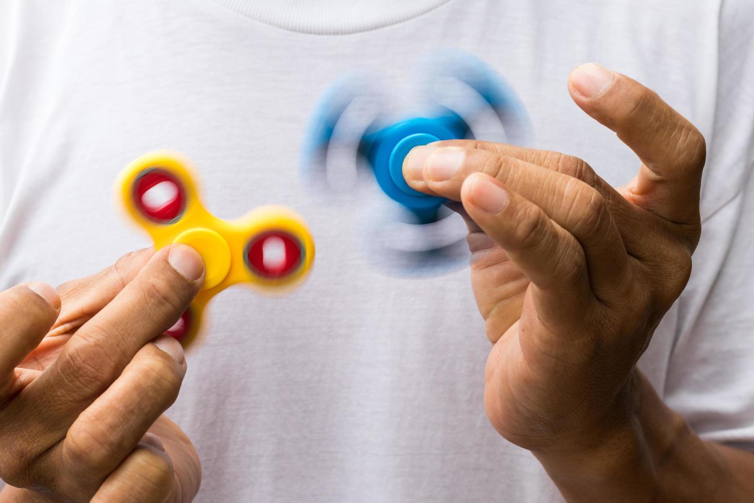 Blue and yellow spinners both in hands. photo