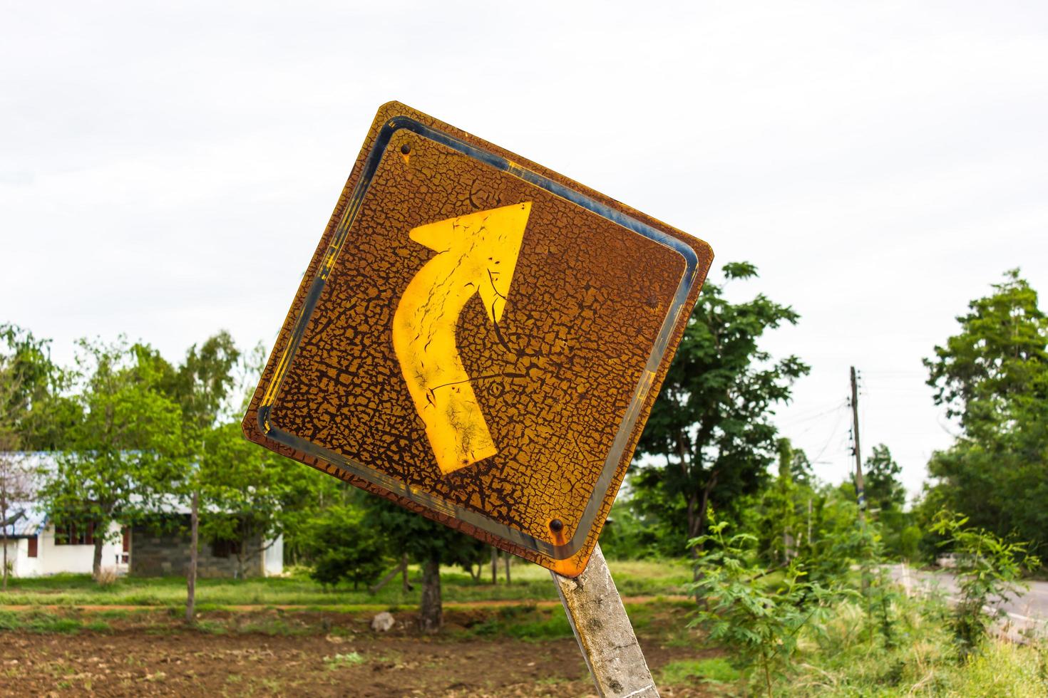 Rusty old sign, turn right tilt. photo