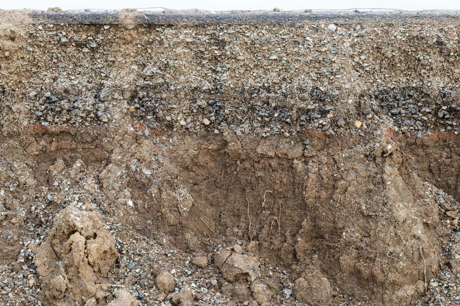 Rocky soil background under paved road. photo