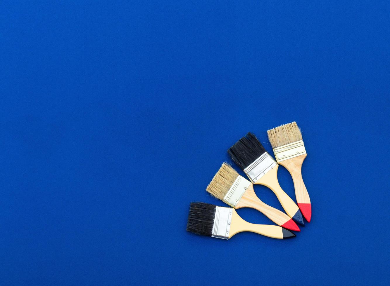 Four painted brushes on blue cloth. photo