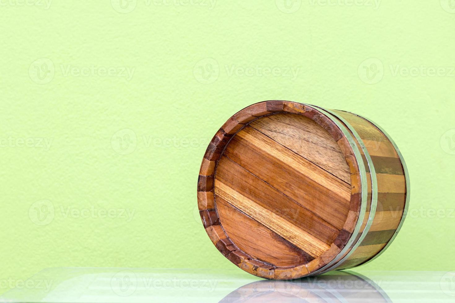 Bottom of classic wooden barrel with classic green wall. photo