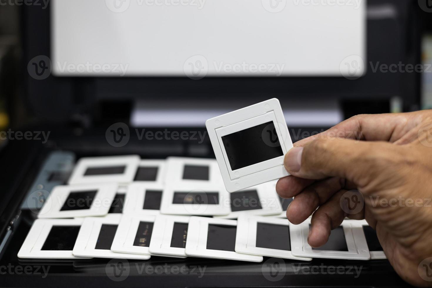 Close-up view of the hand picked up a lot of slide films arranged in rows. photo