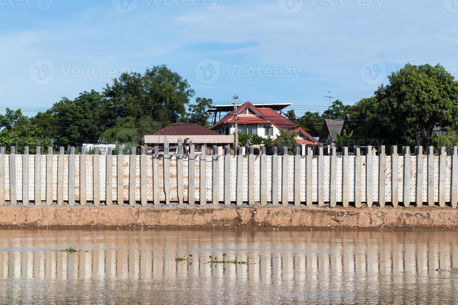 Wall of concrete pillars blocking the river. photo