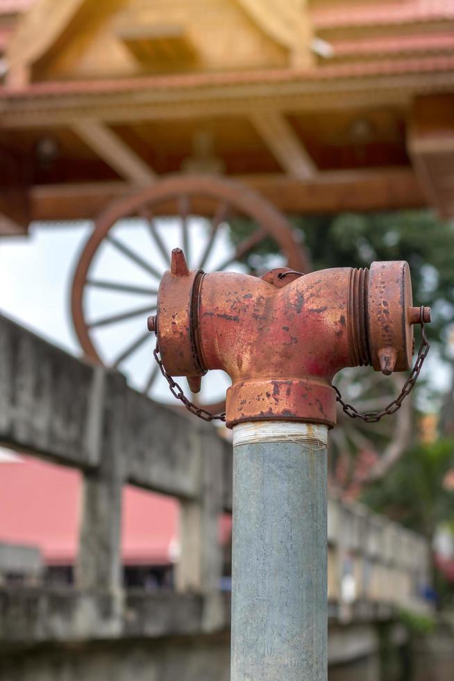 cabeza de tubo de válvula de extintor rojo con puente borroso. foto